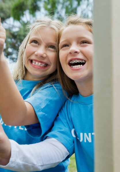 Two young girls smiling with braces