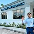 Doctor Ovy smiling and waving in front of Oceanside Orthodontics