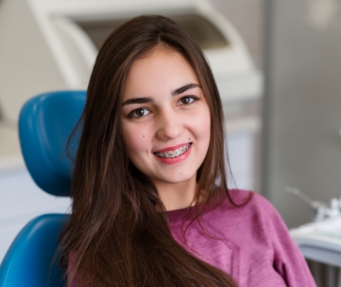Teenage girl with braces smiling after orthodontic services in Fort Lauderdale