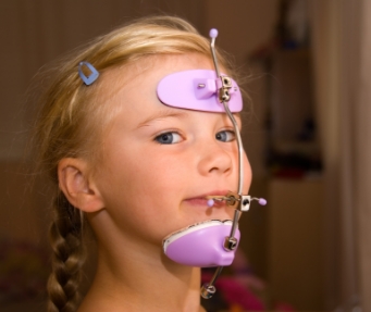 Young girl with braids wearing orthodontic headgear