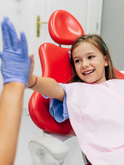 Young girl giving high five to pediatric orthodontist in Fort Lauderdale