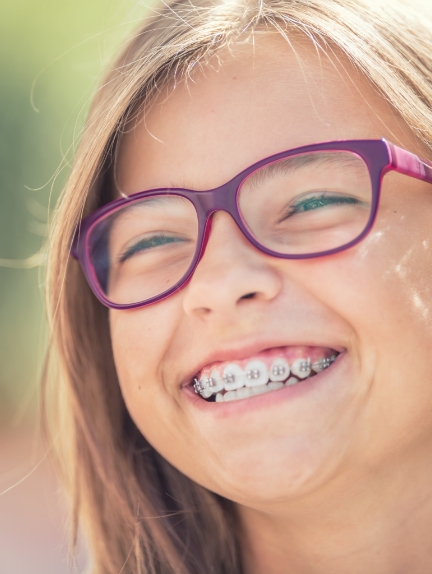 Smiling teenage girl with glasses and traditional braces in Fort Lauderdale