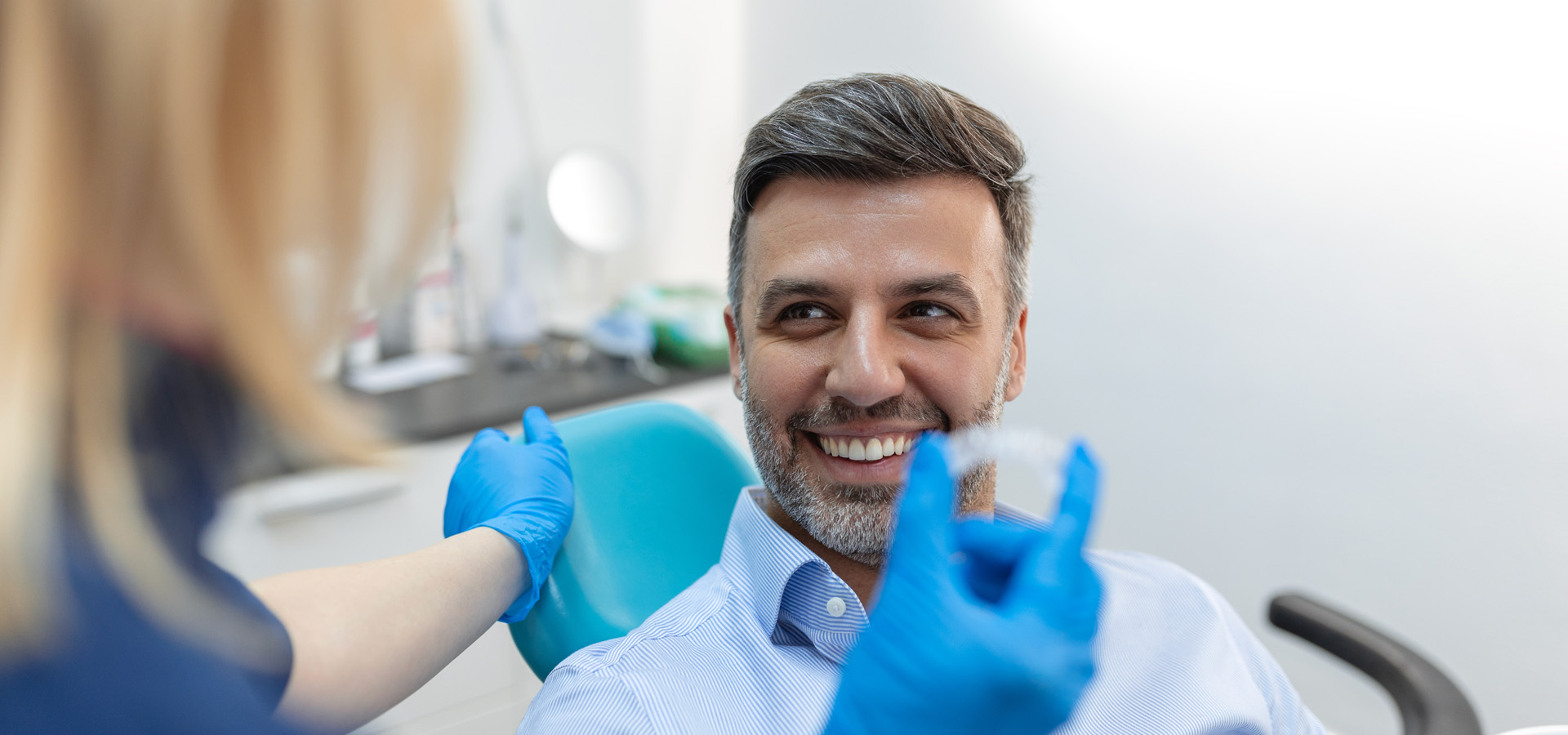 A young female dentist showing invisalign to patient in dental clinic.
