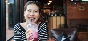 Woman with braces enjoying a smoothie.