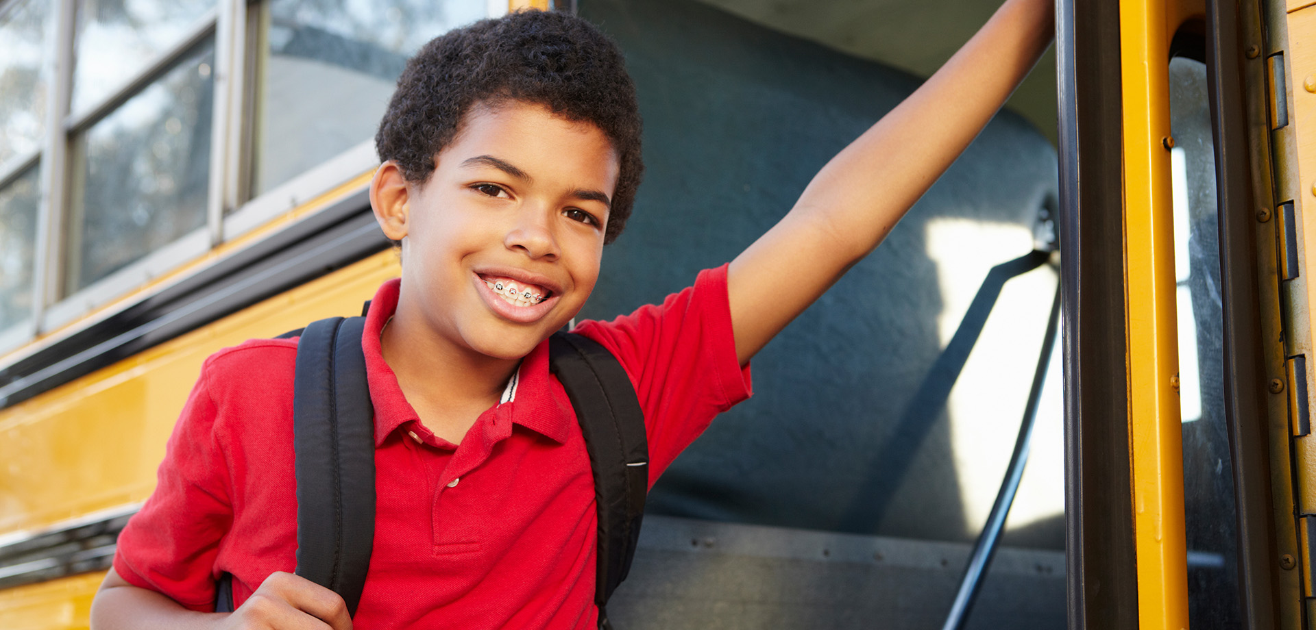 Teen boy getting on school bus