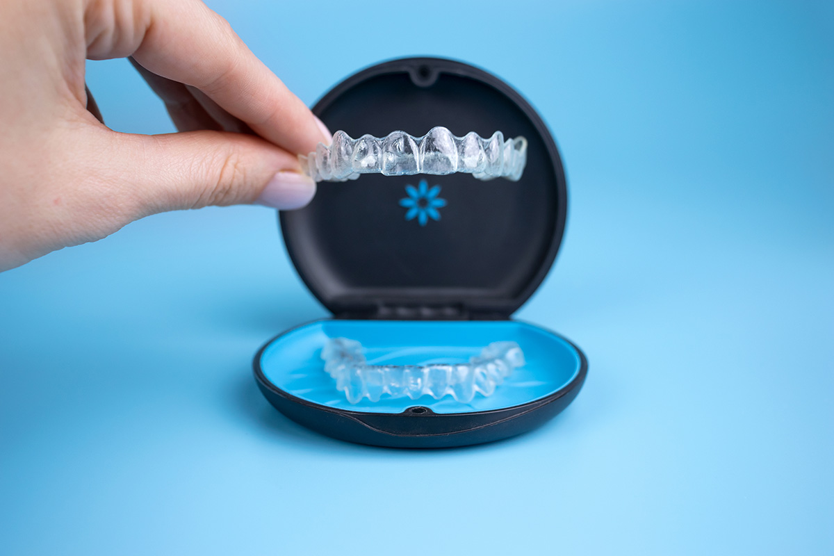 Woman holding Invisalign aligners.