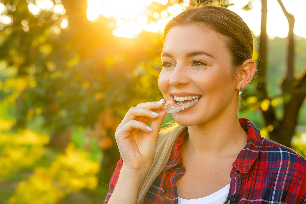 Young woman  using invisible braces or Invisalign.