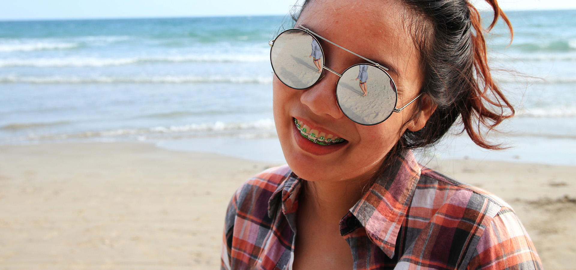 Woman on Fort Lauderdale beach with braces smiling.