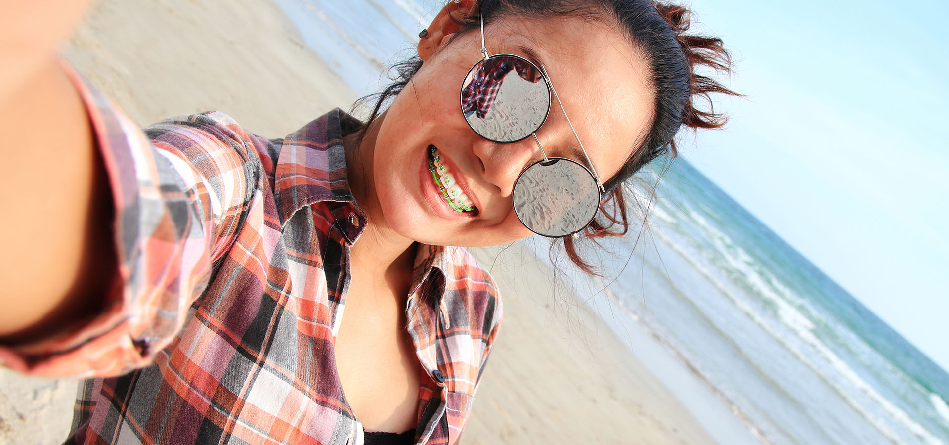 Young woman taking a selfie on the beach.