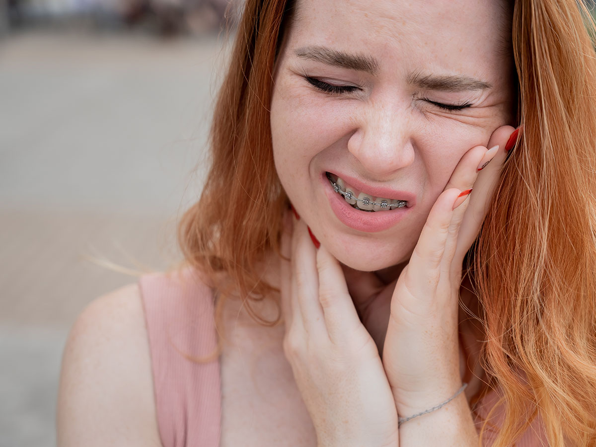 Young woman with braces suffering from pain